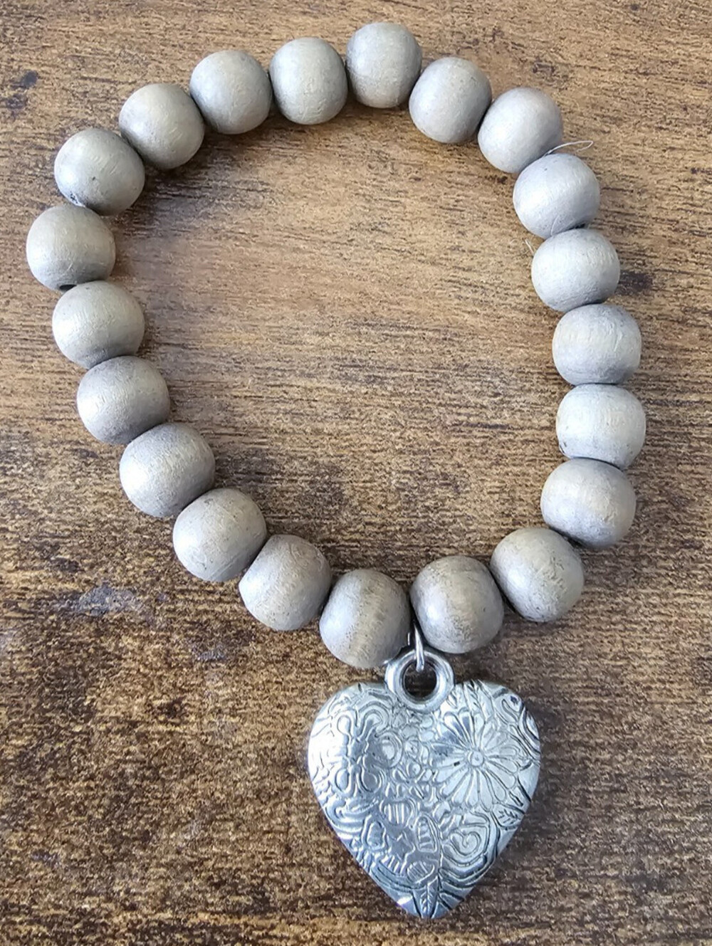 Blessing Beads bracelet featuring gray wooden beads and a textured heart pendant
